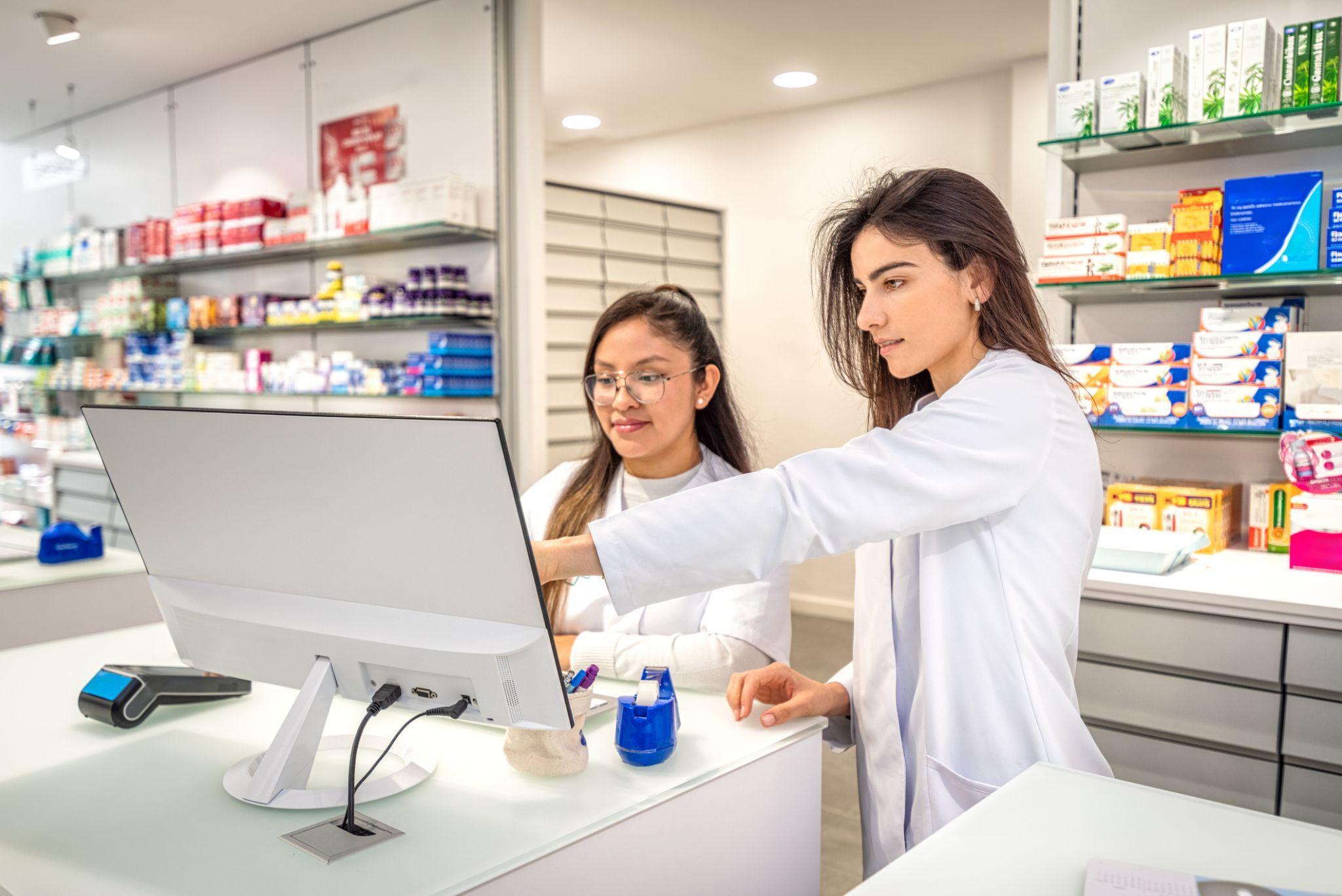 Dos farmacéuticas consultando juntas en el mostrador